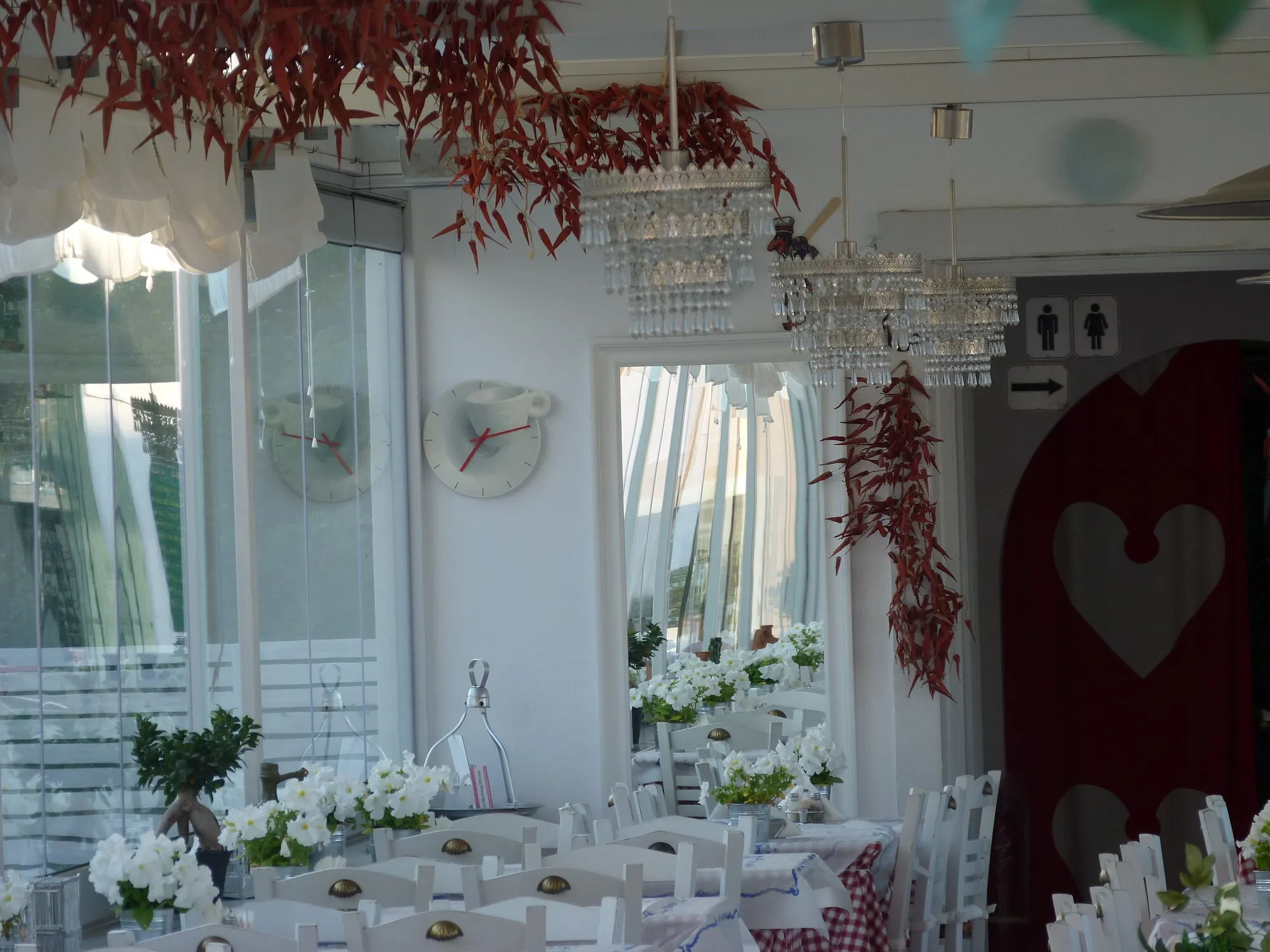 The dining room, with white chairs and hanging chillies